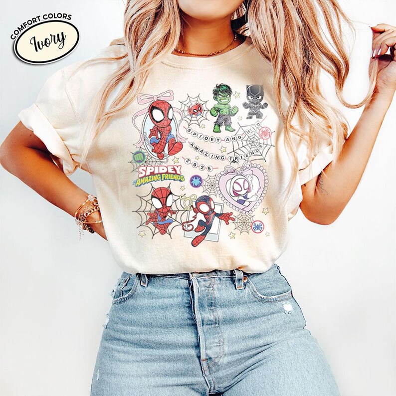 以下が含まれることがあります： スパイダーマン、ハルク、ブラックパンサー、スパイダーグウェンの漫画イラストが描かれたアイボリー色のTシャツ。「Spidey and His Amazing Friends 2023」の文字も含まれています。柔らかい素材で作られたTシャツです。
