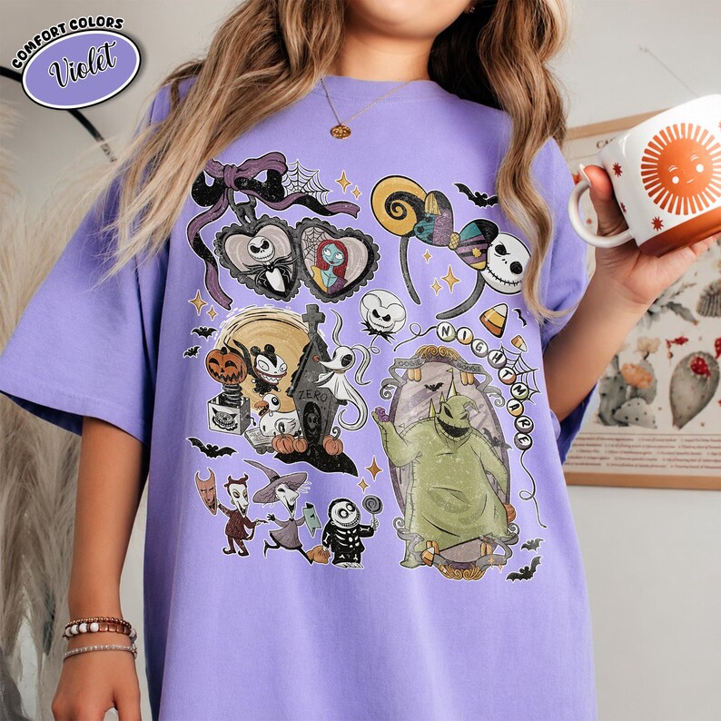 May include: A violet t-shirt featuring a graphic print of characters and icons from The Nightmare Before Christmas, including Jack Skellington, Sally, Oogie Boogie, Zero, and Lock, Shock, and Barrel, arranged in a collage with spiderwebs and bats.