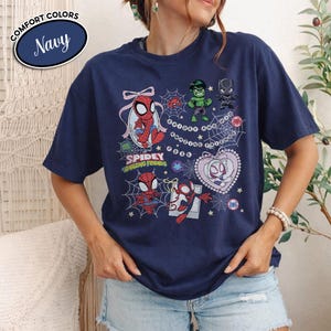 以下が含まれることがあります： スパイディとそのアメイジング・フレンズのキャラクターが描かれたネイビーブルーのTシャツ。グラフィックには、スパイダーマン、ハルク、ブラックパンサー、スパイダーグウェン、クモの巣と星が含まれています。このシャツはクルーネックで半袖です。