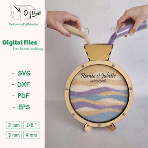 Puede incluir: Un juego de ceremonia de arena de madera con un marco circular, con capas de arena beige, lavanda y azul. El texto "Roméo et Juliette 14/02/2026" es visible. Diseñado para corte por láser.