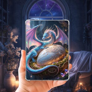 Peut inclure: Une coque de tablette rectangulaire présentant une illustration vibrante d'un dragon bleu clair aux ailes irisées enroulé autour d'un grand œuf orné et lumineux niché dans un nid sombre et complexe avec des cristaux violets à la base.