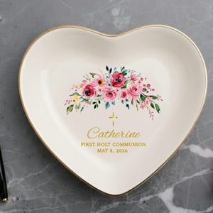 May include: Heart-shaped trinket dish with a floral design in pink, red, and yellow. The dish has a gold rim and includes the text "Catherine, First Holy Communion, May 8, 2026".