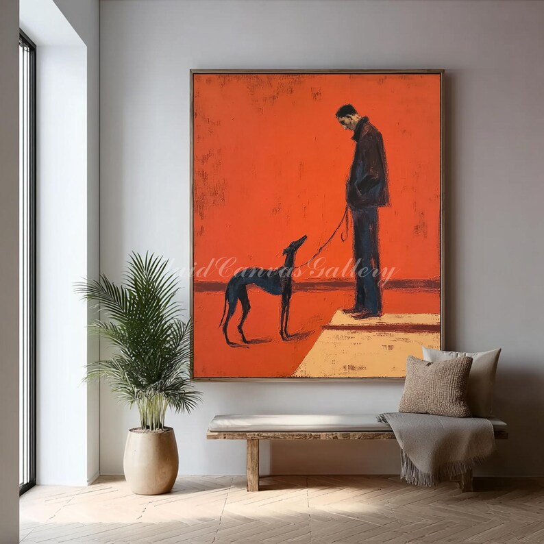 May include: An abstract painting features a person standing with a dog on a leash against a vibrant orange background. The dog is black, and the person is wearing dark clothing. The artwork is framed in a wooden frame and hangs above a wooden bench.