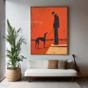May include: An abstract painting on canvas featuring a person and a dog on a leash against a vibrant orange background. The artwork has a minimalist style with a dark color palette, and is framed in a wooden frame. The painting is displayed in a living room setting.