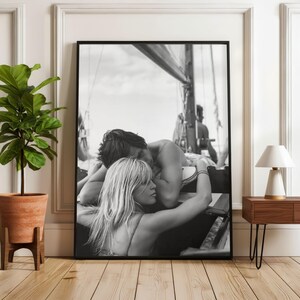 K&ouml;nnte beinhalten: Schwarz-Wei&szlig;-Druck in einem Rahmen, der ein sich umarmendes Paar auf einem Segelboot zeigt. Das Bild zeigt einen intimen Moment des Paares. Der Hintergrund zeigt das Takelwerk des Bootes und den Himmel.