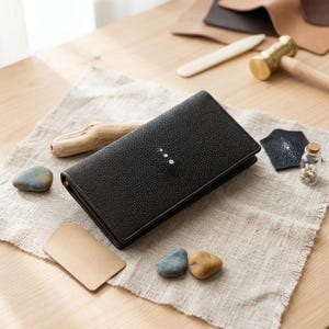 Puede incluir: Un juego de tres tazas de cerámica con un acabado mate moteado. Las tazas son en tonos crema, gris claro y gris oscuro. Cada taza tiene un diseño simple y minimalista, ideal para café o té.