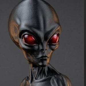 May include: A black alien figurine featuring a smooth, elongated head, a slender neck, and prominent, glossy red eyes. The sculpture displays a textured surface with visible layer lines, capturing the head and upper torso of the extraterrestrial being.