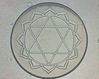 May include: A gray, circular mandala with a six-pointed star design and a surrounding circle of petals.