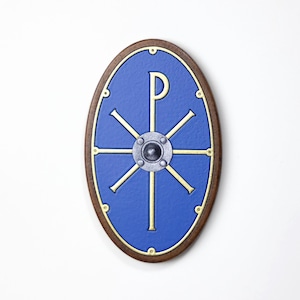 Könnte beinhalten: Ein ovaler Schild mit blauem Zentrum und braunem Holzrahmen. Der Schild hat ein goldfarbenes Design mit einem zentralen Emblem und radialen Linien. In der Mitte befindet sich eine silberfarbene Niete.