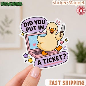 May include: A die-cut sticker or magnet featuring a light yellow duck standing on a pink laptop. The duck holds a small knife. A purple speech bubble contains the text DID YOU PUT IN A TICKET? with additional decorative stars and hearts.