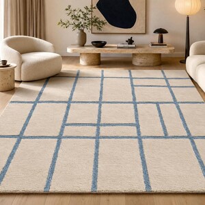 Large beige blue geometric rug featuring an irregular grid design with fine hand tufted detailing and soft texture.