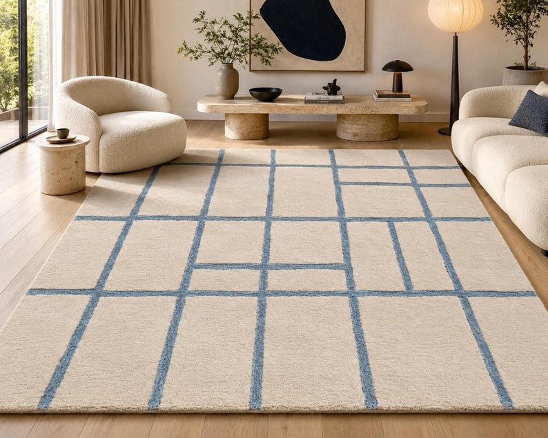 Large beige blue geometric rug featuring an irregular grid design with fine hand tufted detailing and soft texture.