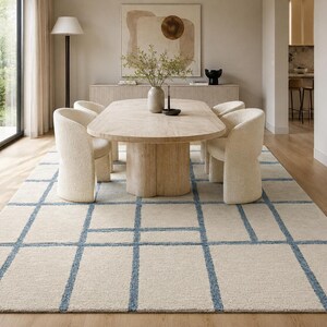 Minimalist hand tufted grid rug in cream, beige, and blue adding subtle texture to contemporary home decor.