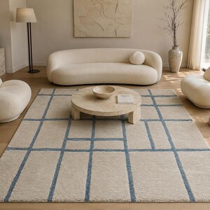 Hand tufted beige and blue grid rug with abstract windowpane pattern for modern minimalist living room decor.