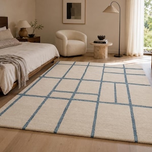 Contemporary beige area rug with delicate blue windowpane lines creating a clean and minimalist geometric design.