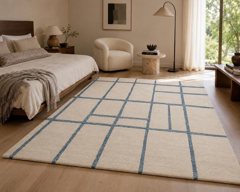 Contemporary beige area rug with delicate blue windowpane lines creating a clean and minimalist geometric design.