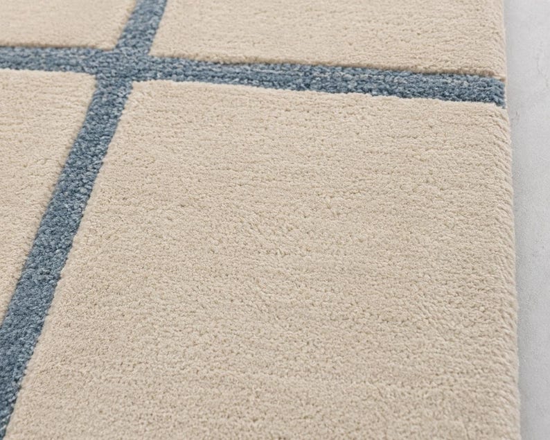 Modern beige and blue geometric rug with irregular windowpane design in closeup shot