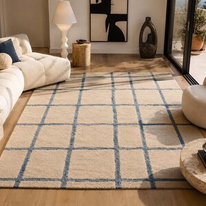 Scandinavian style area rug with abstract blue line pattern on a soft beige background for modern interiors.