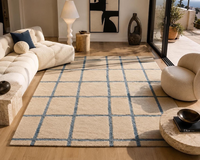 Scandinavian style area rug with abstract blue line pattern on a soft beige background for modern interiors.