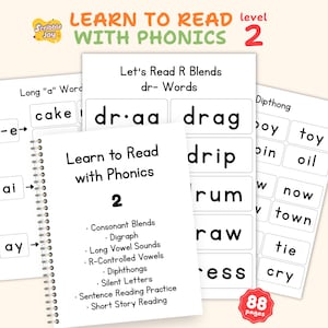 Pode incluir: Materiais educativos para aprender fonética. A imagem mostra um caderno com espiral e cartões com palavras e conceitos fonéticos. A capa do caderno diz "Learn to Read with Phonics 2". Os cartões apresentam palavras como "cake", "drag" e "boy".