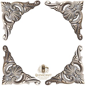 May include: Four antique brass corner brackets with ornate floral and scroll designs. Each bracket is a right angle shape with mounting holes. The brackets are arranged in a square, with the QuenaCraft logo in the center.