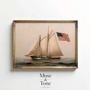 May include: A framed wall art print depicting a vintage sailboat with beige sails navigating dark green ocean waves. An American flag is attached to the mast, waving in the wind. The artwork is enclosed in a thin, weathered gold-toned frame.