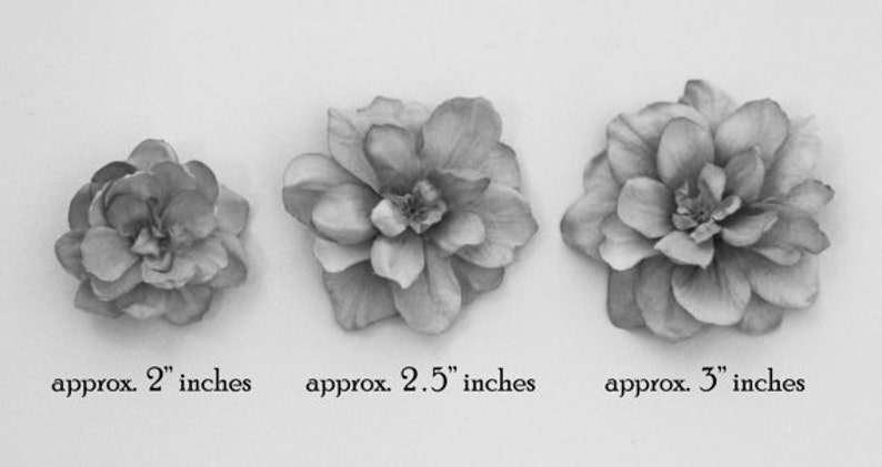 May include: Three gray fabric flower embellishments in different sizes. The smallest flower measures approximately 2 inches in diameter, the middle flower measures approximately 2.5 inches in diameter, and the largest flower measures approximately 3 inches in diameter.