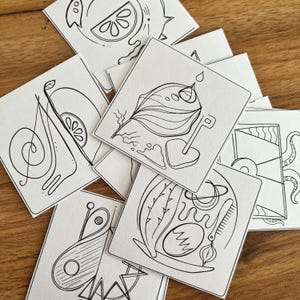 Può includere: Una collezione di cartoncini quadrati bianchi con illustrazioni a linee nere. Ogni cartoncino mostra disegni astratti unici, tra cui una fetta di agrume, una foglia con una goccia d'acqua, una chiave, un pettine e varie forme geometriche e motivi.