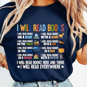 May include: Navy blue t-shirt with the text "I Will Read Books" in white and colorful illustrations. The shirt lists various places to read, including on a boat, in the rain, and with a fox.