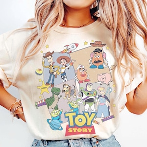 Puede incluir: Sudadera de cuello redondo color crema con un gr&aacute;fico colorido de los personajes de Toy Story. El dise&ntilde;o incluye a Woody, Buzz Lightyear y otros personajes de la pel&iacute;cula animada, con las palabras "TOY STORY" en rojo y amarillo.