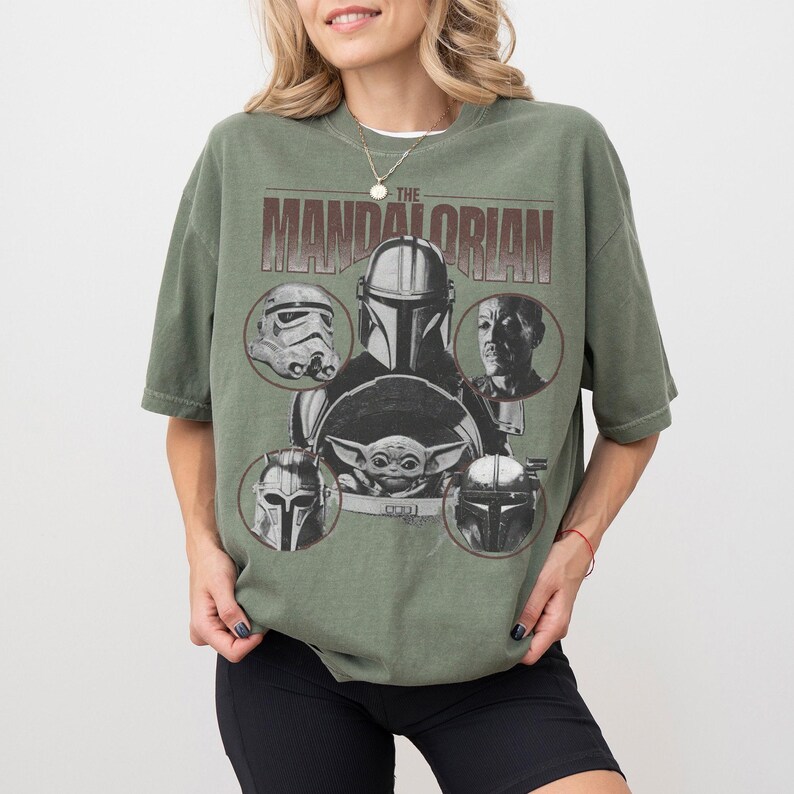 Pu&ograve; includere: T-shirt verde oliva con grafica di "The Mandalorian". Il design include il titolo dello show e immagini di personaggi come il Mandaloriano, Grogu e Stormtroopers. La maglietta ha maniche corte e una vestibilit&agrave; ampia.