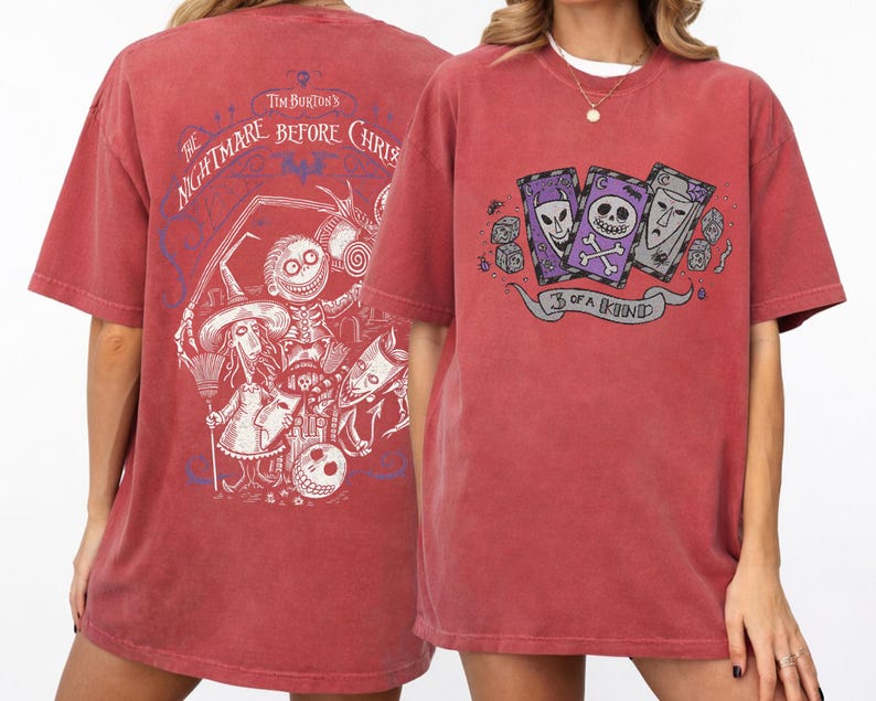 May include: Red-brown t-shirt featuring graphics from "The Nightmare Before Christmas." The front displays three playing cards with skull and alien designs, and the text "3 of a Kind." The back has a detailed character illustration.