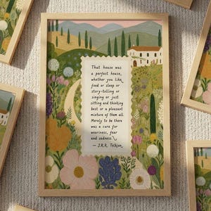 Può includere: Diverse stampe artistiche incorniciate con un'illustrazione di paesaggio con una casa bianca, dolci colline e fiori colorati. Ogni stampa ha una cornice in legno e include una citazione di J.R.R. Tolkien.