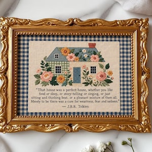 Può includere: Una cornice rettangolare dorata e decorata contenente un ricamo a punto croce di una casa con fiori sul tetto e sulle pareti. Lo sfondo è a quadretti blu e bianchi. Il testo recita: "That house was a perfect house..." di J.R.R. Tolkien.