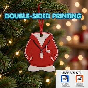 May include: A red hoodie-shaped Christmas ornament with white trim, a black drawstring, and a white whistle graphic. The ornament hangs from a red ribbon and features the text DOUBLE-SIDED PRINTING. The design includes a small pocket detail.