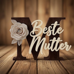 May include: A wooden letter "M" with a white rose and the words "Beste Mutter" in a cursive font. The wooden letter is dark brown, and the rose is white with beige leaves. The background is a wooden surface.