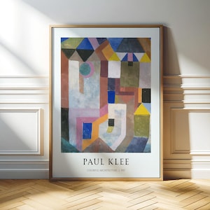 Pode incluir: Uma impressão emoldurada de "Arquitetura Colorida" de Paul Klee de 1927. A obra de arte abstrata apresenta formas geométricas em várias cores, incluindo azul, amarelo, rosa e castanho. O nome do artista e o título são impressos em branco na parte inferior.