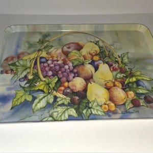 May include: Rectangular serving tray with a painted illustration of a basket overflowing with fruit. The basket includes grapes, pears, peaches, and plums. The tray has a light blue and green background.