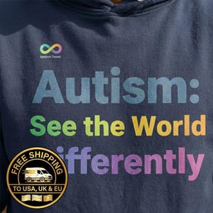 May include: Navy blue hoodie with the text "Autism: See the World Differently" in colorful letters. The hoodie also features a rainbow infinity symbol and the Spectrum Threadz logo.