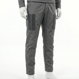 Puede incluir: Pantalones grises con dos parches rectangulares de color gris oscuro en la parte superior del muslo. Los pantalones tienen costuras visibles y forman parte de un conjunto gris a juego. Los pantalones se exhiben en un maniqu&iacute;.