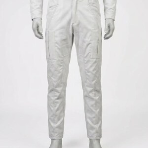 May include: A pair of light gray pants with multiple pockets and stitched detailing. The pants have a straight leg design and a visible zipper and button closure. The garment is displayed on a mannequin.