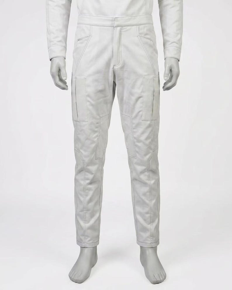 May include: A pair of light gray pants with multiple pockets and stitched detailing. The pants have a straight leg design and a visible zipper and button closure. The garment is displayed on a mannequin.