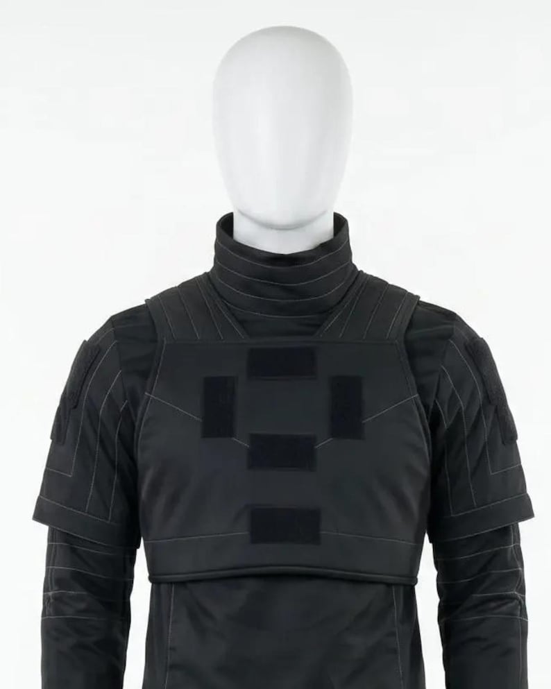 Pode incluir: Colete t&aacute;tico preto com gola alta e ombreiras. O colete apresenta patches retangulares no peito e &eacute; usado sobre uma camisa preta de manga comprida. O manequim est&aacute; sobre um fundo branco.