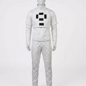 May include: A full-body white futuristic costume on a mannequin. The outfit includes a turtleneck shirt, a short-sleeved vest with black rectangular accents, long-sleeved shirt, and matching pants with pockets. The mannequin has a blank face.