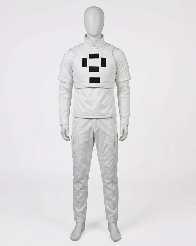 May include: A full-body white futuristic costume on a mannequin. The outfit includes a turtleneck shirt, a short-sleeved vest with black rectangular accents, long-sleeved shirt, and matching pants with pockets. The mannequin has a blank face.