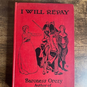 Pode incluir: Um livro vintage intitulado "I Will Repay" de Baroness Orczy, autora de "The Scarlet Pimpernel". A capa é vermelha com ilustrações pretas de figuras em trajes de época. O título do livro está em letras brancas em negrito.