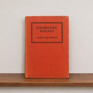 May include: A hardcover book with a solid orange cover and a black rectangular border on the front. The text inside the border reads "ELEMENTARY ANALYSIS" on the top line and "DAKIN AND PORTER" on the bottom line in a black serif font.