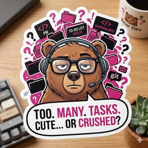 May include: A sticker featuring a brown bear wearing glasses and a headset, surrounded by pink file folders and question marks. Text reads "TOO. MANY. TASKS. CUTE... OR CRUSHED?" and "OVERWHELMED!" The bear is labeled "Bear Dev."