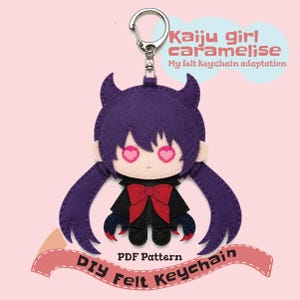 May include: A felt keychain featuring a purple-haired character with heart-shaped eyes, a black jacket, and a red bow. The text reads: Kaiju girl caramelise My felt Keychain adaptation and PDF Pattern DIY Felt Keychain.