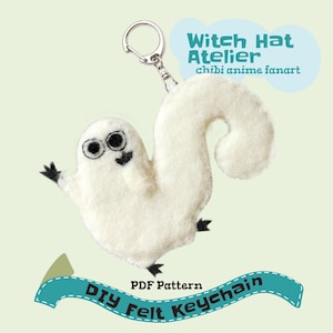Può includere: Un portachiavi in feltro bianco a forma di scoiattolo con occhi ricamati neri, una piccola bocca e zampe nere. Il portachiavi presenta un anello in metallo argentato. Il testo recita: Witch Hat Atelier chibi anime fanart e PDF Pattern DIY Felt Keychain.